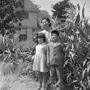 Mrs. Hiroshi Kawahara and her children, Seichi and Seiko, in their garden at Route 3, Box 389, Petaluma, California. Mr. Kawahara is working for Mr. Polonisky, a grower in the vicinity. The Kawaharas are former residents of Granada. —Photographer: Iwasaki, Hikaru—Petaluma, California. 8/8/45